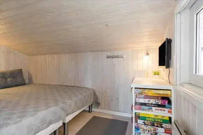 a small bedroom with a bed and a tv at BL1706-Blokhus-Bloksbjerg-91 in Blokhus