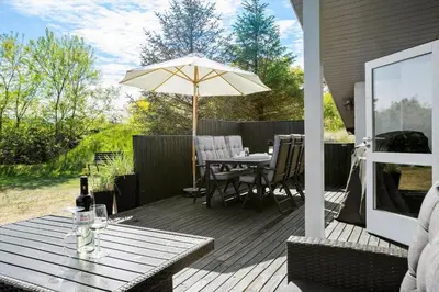 a patio with a table and an umbrella at BL1706-Blokhus-Bloksbjerg-91 in Blokhus