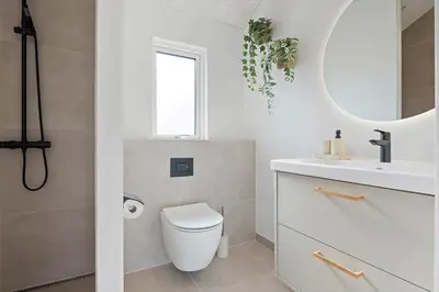 a bathroom with a toilet and a sink and a mirror at LK2146-Lokken-Redningsstien-2 in Løkken