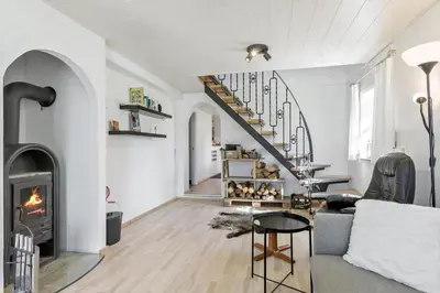 a living room with a fireplace and a staircase at BL1454-Pandrup-Rodhusvej-215 in Pandrup