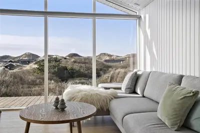 a living room with a couch and a large window at BL1450-Blokhus-Klitvejen-99 in Blokhus