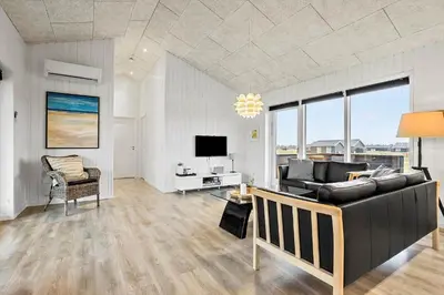 a living room with a couch and a television at LK2167-Lokken-Kringelbaekvej-12 in Løkken