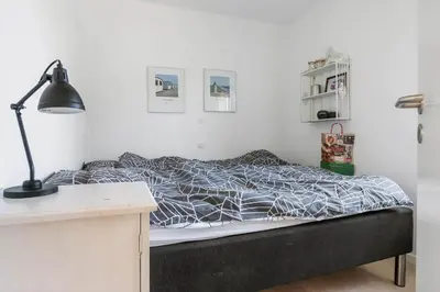 a bedroom with a bed and a desk with a lamp at BL1637-Blokhus-Norresundbyvej-2 in Blokhus