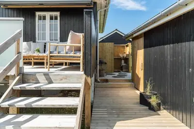 a wooden deck with a bench on a house at BL1637-Blokhus-Norresundbyvej-2 in Blokhus