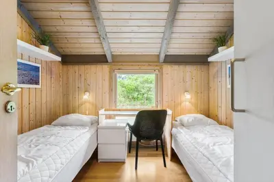 a room with two beds and a desk and a chair at BL1438-Blokhus-Bloksbjerg-82 in Blokhus