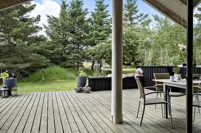 a wooden deck with a table and chairs on it at BL1438-Blokhus-Bloksbjerg-82 in Blokhus