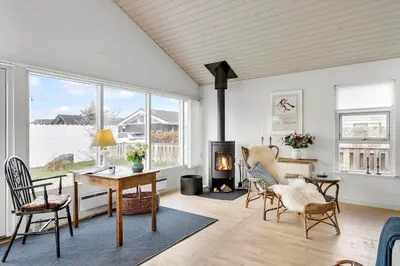a living room with a table and chairs and a fireplace at BL1425-Blokhus-N-S-Larsensvej-6 in Blokhus