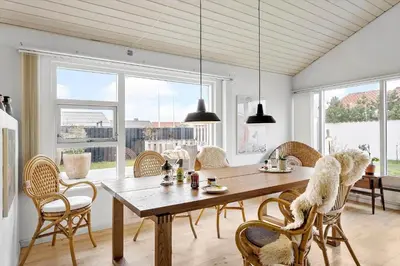 a dining room with a wooden table and chairs at BL1425-Blokhus-N-S-Larsensvej-6 in Blokhus