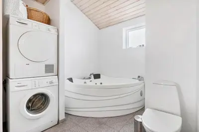 a bathroom with a washing machine and a sink at BL1619-Blokhus-Klitheden-Nord-42 in Blokhus