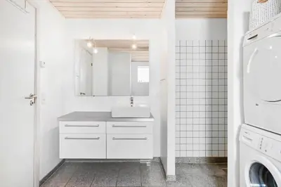 a white bathroom with a sink and a washing machine at BL1619-Blokhus-Klitheden-Nord-42 in Blokhus