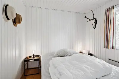 a white bedroom with a bed and a night stand at BL1716-Saltum-Viborgvej-2 in Saltum