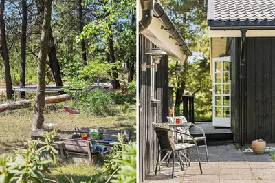 a house with a table and chairs on a patio at BL445-Blokhus-Bag-Hojen-65 in Blokhus