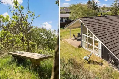 a small house with a picnic table in the grass at BL1382-Blokhus-Gyvelvej-20-A in Blokhus