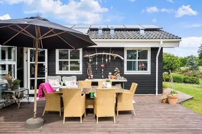 a patio with a table and chairs and an umbrella at BL1577-Blokhus-Lars-Liensvej-27 in Blokhus