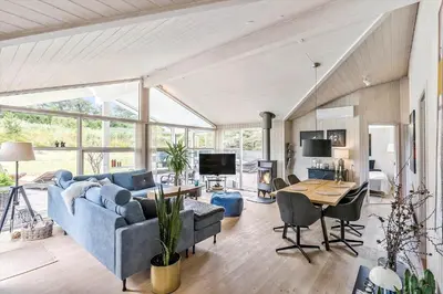 a living room with a blue couch and a table at BL1577-Blokhus-Lars-Liensvej-27 in Blokhus