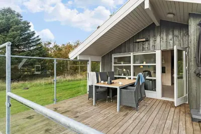 a patio with a table and chairs on a deck at BL1255-Pandrup-Rodhusparken-63 in Pandrup