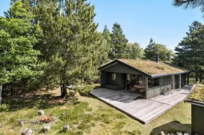 a cabin with a grass roof with a deck at BL1735-Pandrup-Rodhus-Skolevej-56 in Pandrup