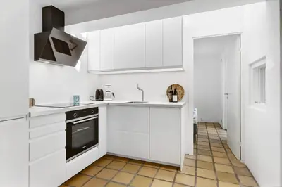 a white kitchen with a sink and a stove at BL1538-Blokhus-Ferren-42 in Blokhus
