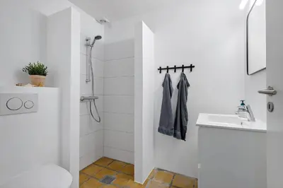 a white bathroom with a toilet and a sink at BL1538-Blokhus-Ferren-42 in Blokhus