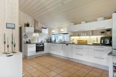 a large kitchen with white cabinets and appliances at BL1566-Saltum-Lille-Fiskerbanke-3 in Saltum
