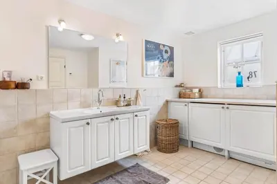 a white bathroom with a sink and a mirror at BL1401-Blokhus-Ferren-Syd-78 in Blokhus