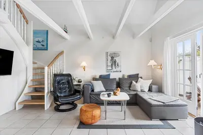 a living room with a couch and a chair at BL1401-Blokhus-Ferren-Syd-78 in Blokhus