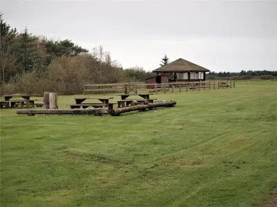 a field with picnic tables and a gazebo at BL1674-Pandrup-Kystvejen-19 in Pandrup