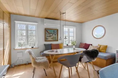 a living room with a table and chairs at BL1548-Blokhus-Paa-Bakken-10 in Blokhus