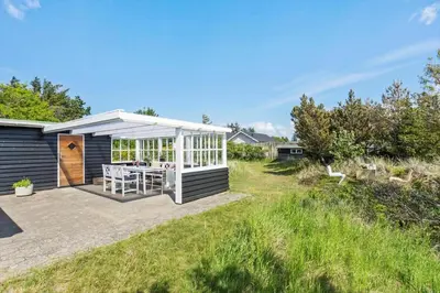 a small shed with a table in the backyard at BL1548-Blokhus-Paa-Bakken-10 in Blokhus