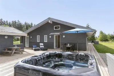 a hot tub on a deck next to a house at BL1358-Saltum-Solmarken-5 in Saltum