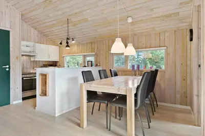 a kitchen and dining room with a table and chairs at BL224-Pandrup-Rodhusparken-91 in Pandrup