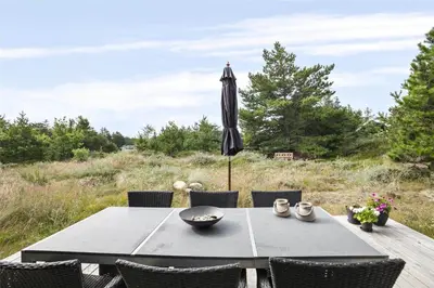 an umbrella sitting on a table with chairs at BL377-Blokhus-Maxvej-9 in Blokhus