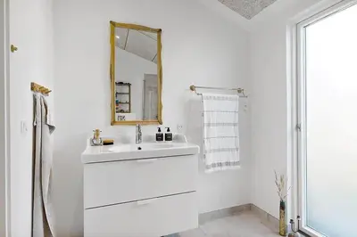 a white bathroom with a sink and a mirror at BL1231-Pandrup-Lunen-54 in Pandrup