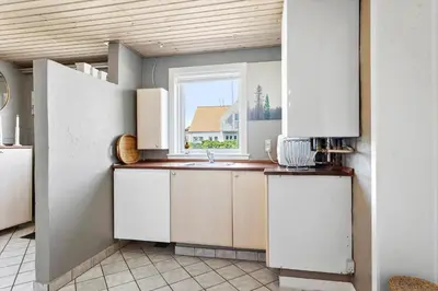 a kitchen with white cabinets and a window at BL509-Blokhus-Jens-Baerentsvej-7 in Blokhus