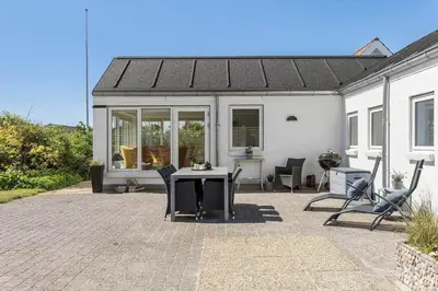 a patio with a table and chairs in front of a house at BL509-Blokhus-Jens-Baerentsvej-7 in Blokhus