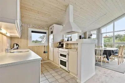 a kitchen and dining room with a dining table at BL314-Blokhus-Bakkevaenget-5 in Blokhus