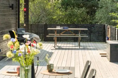 a patio with a table and chairs and a bench at BL1485-Blokhus-Jaegervaenget-2-A in Blokhus