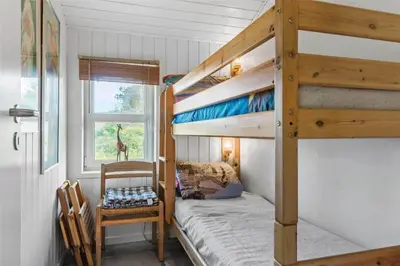 a bedroom with two bunk beds and a chair at BL450-Saltum-Graabakken-8 in Saltum