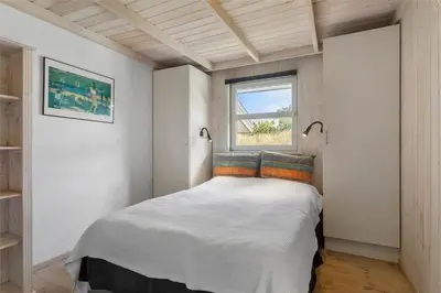 a bedroom with a white bed with a window at BL450-Saltum-Graabakken-8 in Saltum