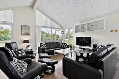 a living room with black leather furniture and a tv at BL1633-Saltum-Nordvestvej-18 in Saltum