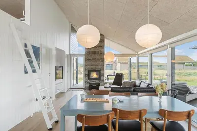 a living room with a table and a fireplace at BL1445-Saltum-Laustvej-7 in Saltum
