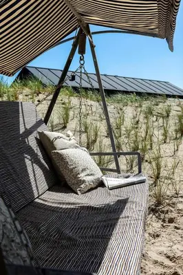 a pillow sitting on a swinging chair on the beach at BL1433-Blokhus-Mollevej-11 in Blokhus