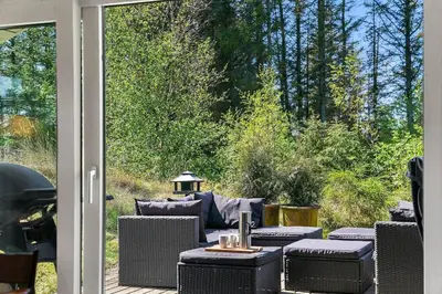 a patio with a table and chairs on a porch at BL1420-Blokhus-Ronliensvej-21 in Blokhus