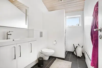 a white bathroom with a toilet and a sink at BL1420-Blokhus-Ronliensvej-21 in Blokhus