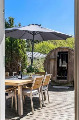 a wooden table with an umbrella on a deck at BL1420-Blokhus-Ronliensvej-21 in Blokhus