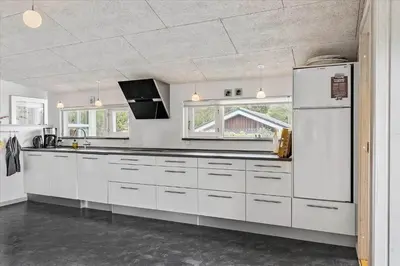 a kitchen with white cabinets and a refrigerator at BL1492-Blokhus-Plantagevej-19-B in Blokhus