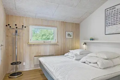 a white bed in a room with a window at BL1492-Blokhus-Plantagevej-19-B in Blokhus