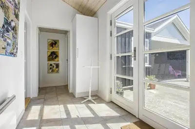 a hallway with a large window and a door at BL1273-Blokhus-Vester-Klitvej-15 in Blokhus