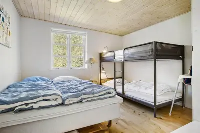 a bedroom with two bunk beds and a window at BL1273-Blokhus-Vester-Klitvej-15 in Blokhus