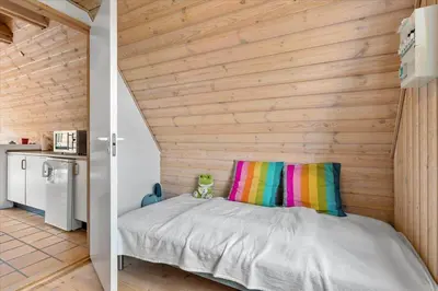 a room with a bed with a wooden wall at BL1738-Pandrup-Narhvalen-11 in Pandrup
